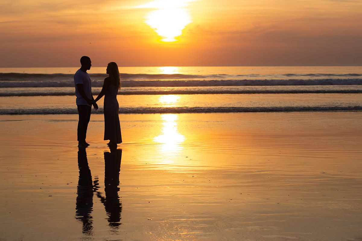 Couple walking beside the sea during a sunset photoshoot in Durrës